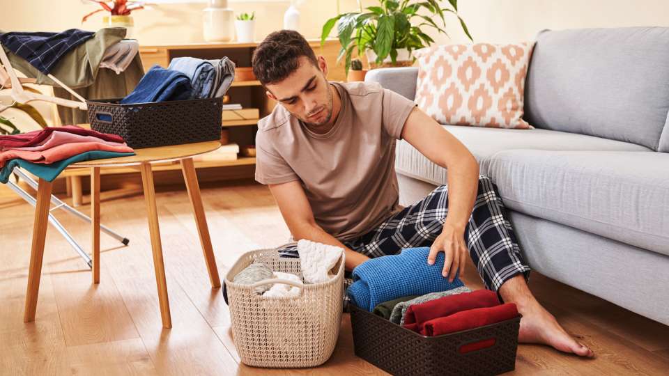 Person quickly tidying up a living room with bins and baskets