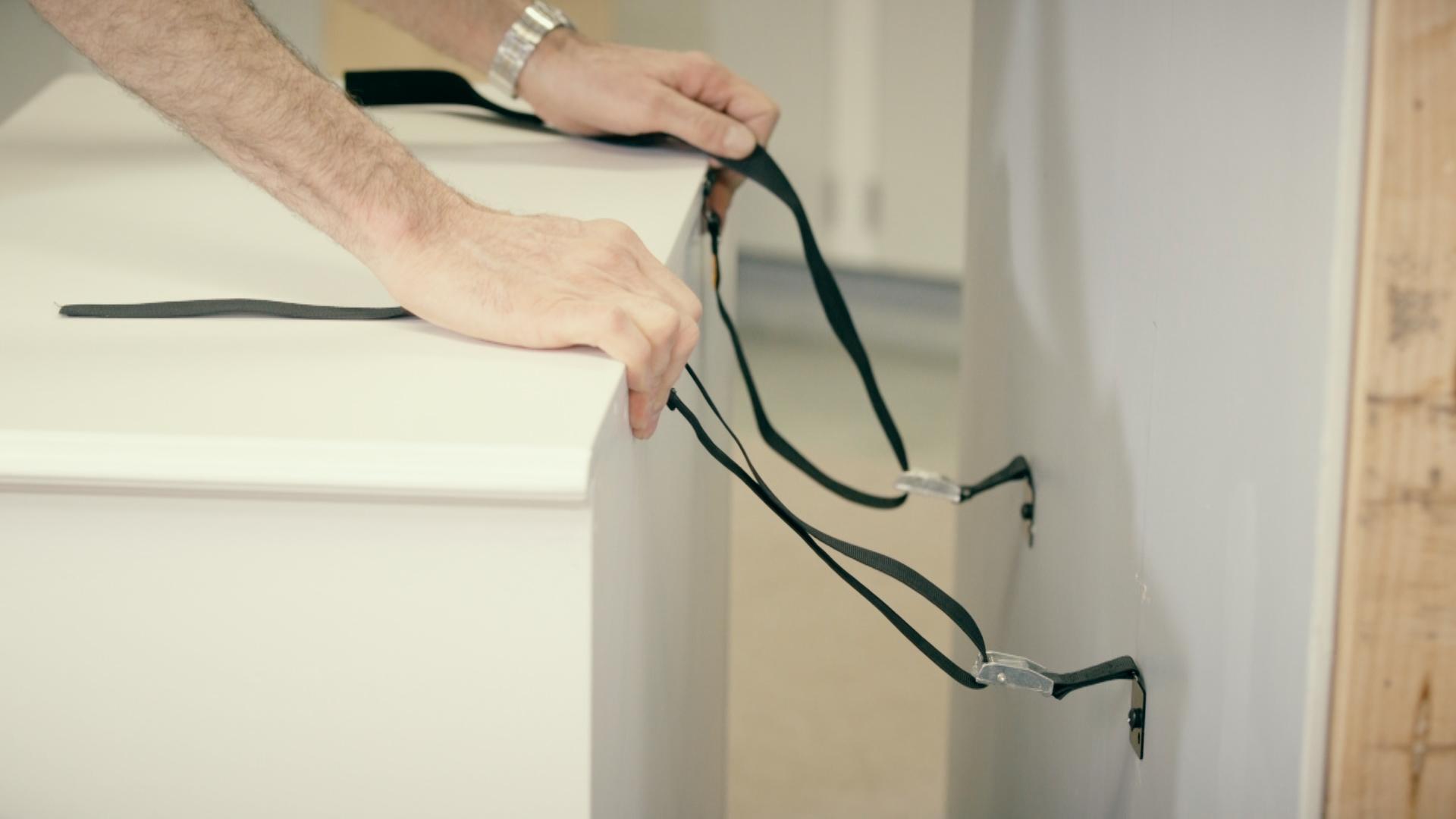 Installing anti-tip straps to secure furniture and prevent tip-overs